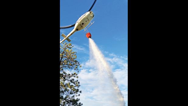  A helicopter drops water on a grass fire in Sweet Grass County Monday night.  Columbus Fire Rescue responded to an agency assist grass fire on the north side of the Stagecoach Estates Subdivision, a couple hundred yards from eastbound I-90. The fire  is believed to have been sparked by lightning. 