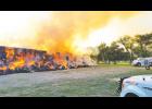 Fire crews watch a 500-ton haystack burn Monday morning while making sure it did not spread to the surrounding grass and structures. 
