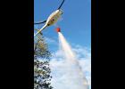  A helicopter drops water on a grass fire in Sweet Grass County Monday night.  Columbus Fire Rescue responded to an agency assist grass fire on the north side of the Stagecoach Estates Subdivision, a couple hundred yards from eastbound I-90. The fire  is believed to have been sparked by lightning. 
